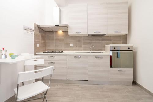 a kitchen with white cabinets and a sink and a counter at Appartamento Bilocale TA in Follonica