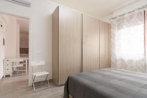 a bedroom with a bed and a chair and a table at Appartamento Bilocale TA in Follonica
