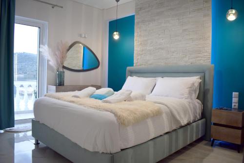 a bedroom with a large bed with blue walls at Seafront Luxury Apartment in Amfilochía