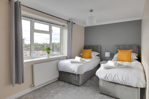 two beds in a room with a window at Modern 1BR Gem - Stylish Flat in Harlow in Great Parndon