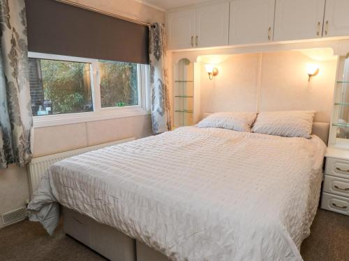 a bedroom with a large white bed and a window at The Goodwood Annex in Chichester