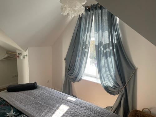 a bedroom with a bed and a window with blue curtains at Kerschbaumer.Apartments in Waidhofen an der Ybbs
