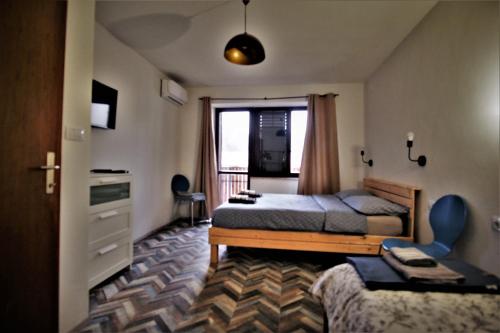 a bedroom with a bed and a chair and a window at OLD SQUARE HOUSE - HIŠA NA STAREM TRGU in Tolmin