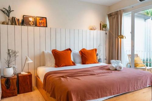 a bedroom with a large bed with orange pillows at wyn in Ko Larn