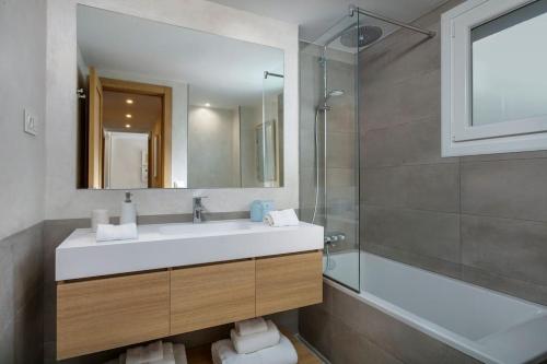 La salle de bains est pourvue d'un lavabo, d'une douche et d'un miroir. dans l'établissement New & Beautiful Apt walk to the beach - RDR251, à Marbella