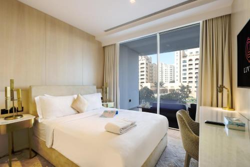 a hotel room with a bed and a large window at Five Palm - Residential 2 BR Suite with Private Beach -Livbnb in Dubai