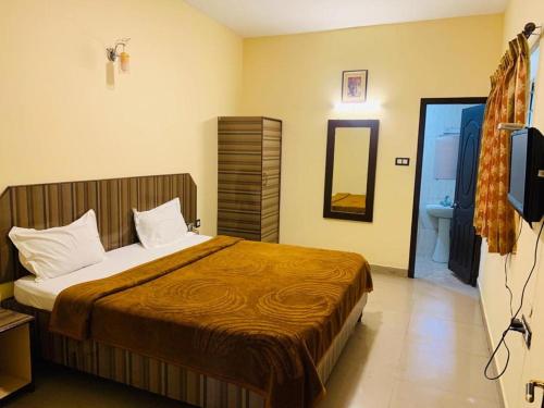 sypialnia z łóżkiem i telewizorem oraz łazienka w obiekcie Le Grace Apoorva w mieście Kodaikānāl