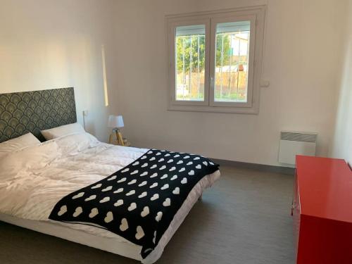 sypialnia z łóżkiem z czarno-białym kocem w obiekcie Belle maison 100m2 avec terrasse et parking privé w Béziers