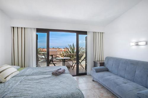 a living room with a couch and a bed and a patio at Amarilla Bay in Costa Del Silencio