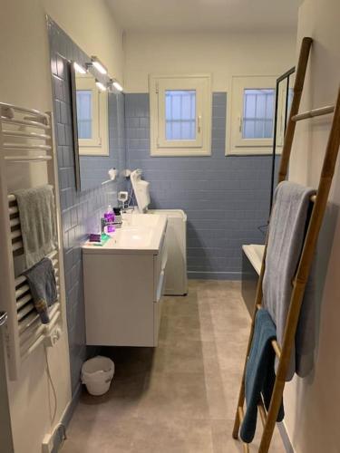 une salle de bain bleue avec un lavabo et un miroir dans l'établissement Belle maison 100m2 avec terrasse et parking privé, à Béziers