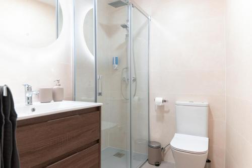 y baño con ducha, aseo y lavamanos. en Downtown Apartment (4 bedrooms, 2 bathrooms, wifi), en Sevilla