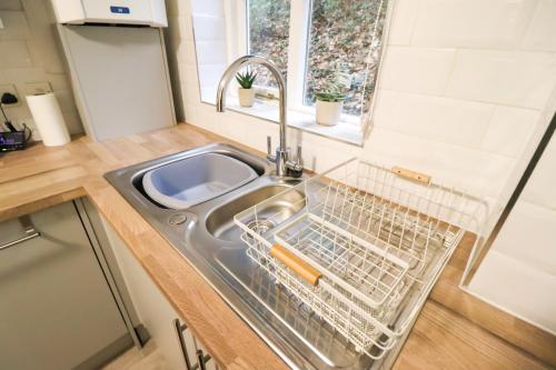 a kitchen sink with a dish drying rack in it at Chic 2BR Flat in Bishop's Stortford in Bishops Stortford
