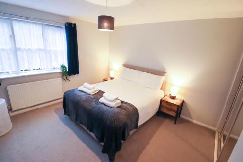 a bedroom with a bed with two towels on it at Chic 2BR Flat in Bishop's Stortford in Bishops Stortford