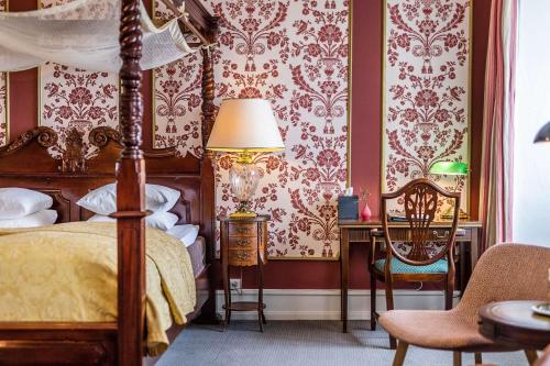 a bedroom with a bed and a table with a lamp at Dragsholm Slot in Hørve