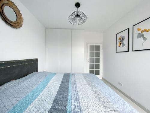 Apartament Kazimierza Wielkiego 5 في بوزنان: غرفة نوم بيضاء مع سرير ومرآة