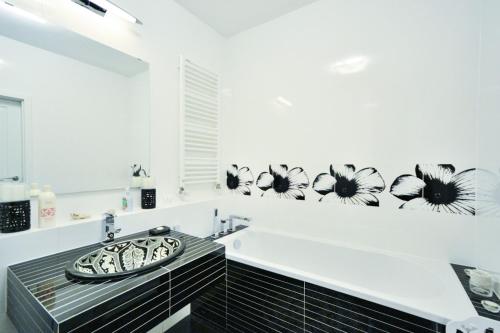 Apartament Kazimierza Wielkiego 5 في بوزنان: حمام مع حوض أسود و أبيض