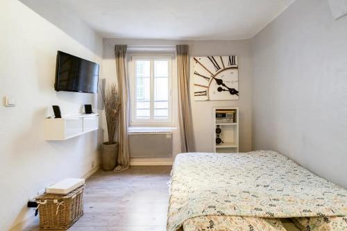 ヴァルボンヌにあるSun Studioのベッドルーム1室(ベッド1台、壁掛け時計付)