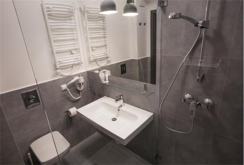a bathroom with a sink and a shower with a mirror at MarcoPolo House in Warsaw