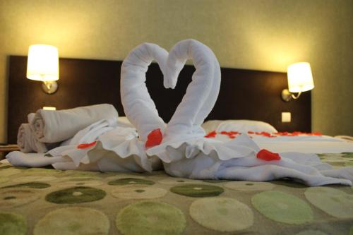 two swans made out of towels on a bed at Hotel Da Montanha in Pedrógão Pequeno