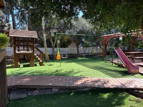 a playground with a slide and a swing set at Arbel Holiday Homes in Arbel