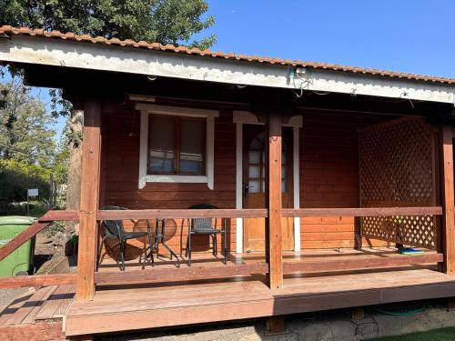 a wooden cabin with a porch and a balcony at Arbel Holiday Homes in Arbel
