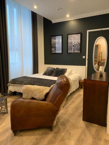 1 dormitorio con cama, silla y espejo en La Clé des Plaisirs en Chambéry