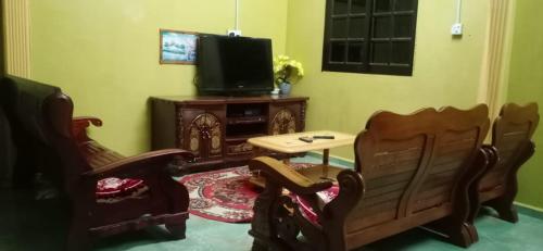a living room with two chairs and a television at D'HANA HOMESTAY in Baling