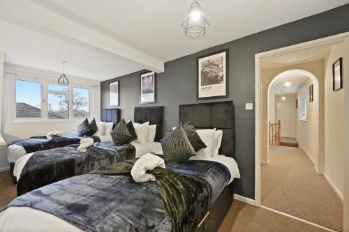 een slaapkamer met drie bedden met kussens erop bij Stylish Abode with Games Room - Sleeps 15 in Brislington