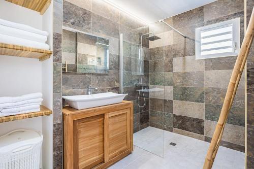 a bathroom with a sink and a shower at villa de prestige Anse ka'nel in Le Moule