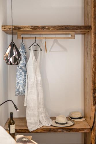 a wedding dress hanging on a wooden shelf in a kitchen at Galazia Boutique Apartments in Naxos Chora