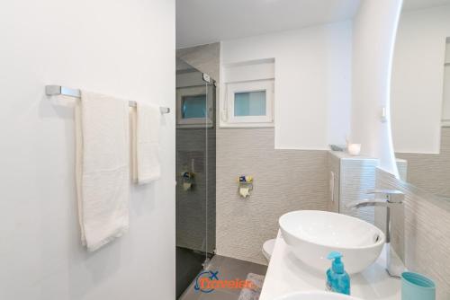 a bathroom with a white toilet and a sink at Villa Hlapa-new modern villa near beach - by TRAVELER tourist agency Krk in Gostinjac