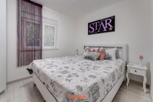 a bedroom with a bed and a sign on the wall at Villa Hlapa-new modern villa near beach - by TRAVELER tourist agency Krk in Gostinjac