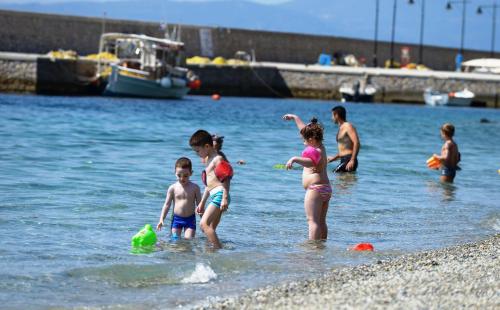 a group of children playing in the water at the beach at Ilia Mare in Ilia