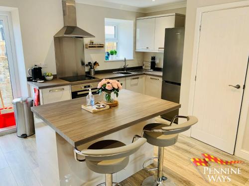 a kitchen with a wooden table with flowers on it at Bleabeck View, Middleton-In-Teesdale in Middleton in Teesdale