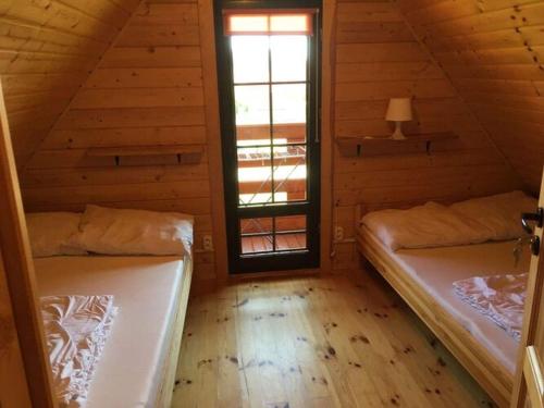 a attic room with two beds and a window at Comfortable holiday homes, Mielenko in Mielenko