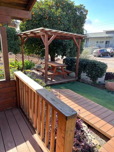 a wooden deck with a picnic table and a wooden bench at Arbel Holiday Homes in Arbel