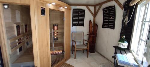 a room with a glass door with a chair and a table at Quinta das Cantigas by Book YourHoliday PT in Aljubarrota