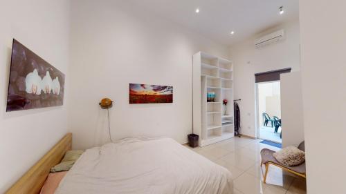 a bedroom with white walls and a bed in it at Spacious 3 bedroom maisonette in Sliema