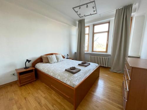A cozy apartment with a wonderful view of the river in the old town of Vilnius في فيلنيوس: غرفة نوم مع سرير وخزانة ونافذة