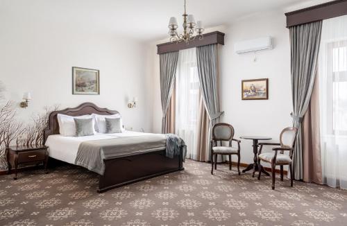 a bedroom with a bed and a table and chairs at Hotel Leul de Aur in Sebeş