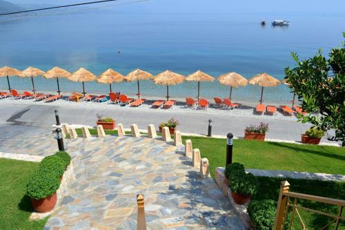 a beach with umbrellas and chairs and the ocean at Ilia Mare in Ilia
