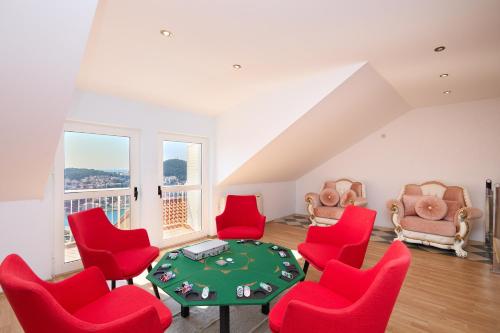 a living room with red chairs and a poker table at Bellevue Duplex Apartment in Dubrovnik