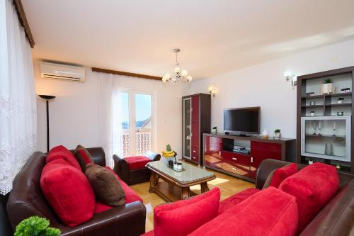 a living room with a red couch and a tv at Bellevue Duplex Apartment in Dubrovnik