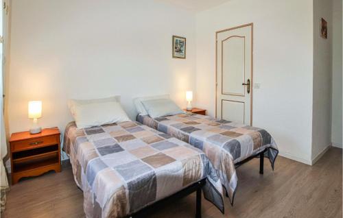 two beds in a room with two lamps on tables at Beautiful Home In Flachres With Kitchen in Flachères