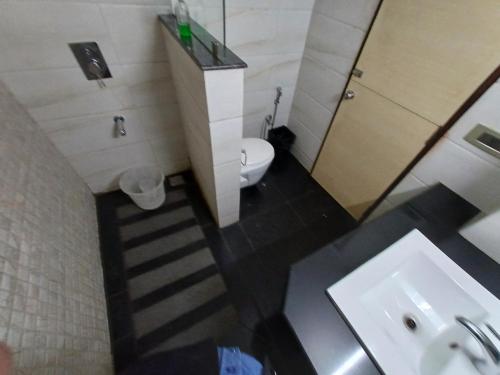 a bathroom with a white toilet and a sink at Broadway Inn in Jaipur