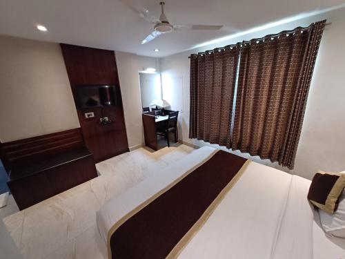 a bedroom with a large bed and a desk at Broadway Inn in Jaipur
