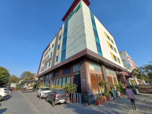 a building with cars parked in front of it at Broadway Inn in Jaipur