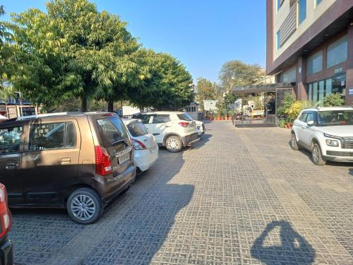 a row of cars parked on the side of a street at Broadway Inn in Jaipur