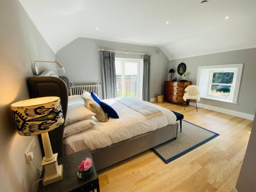 una camera con letto e tavolo con lampada di The Granary, Luxuriously Restored Barn on a Farm a Thurles