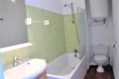 uma casa de banho com uma banheira, um WC e um lavatório. em Appartement 3 pièces 5 à 6 personnes - vue mer - à 200 m de la plage - FANTA em Ploemeur